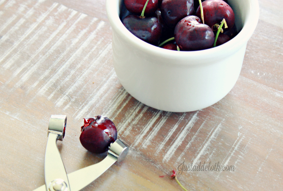 cherry pitter and bowl of cherries